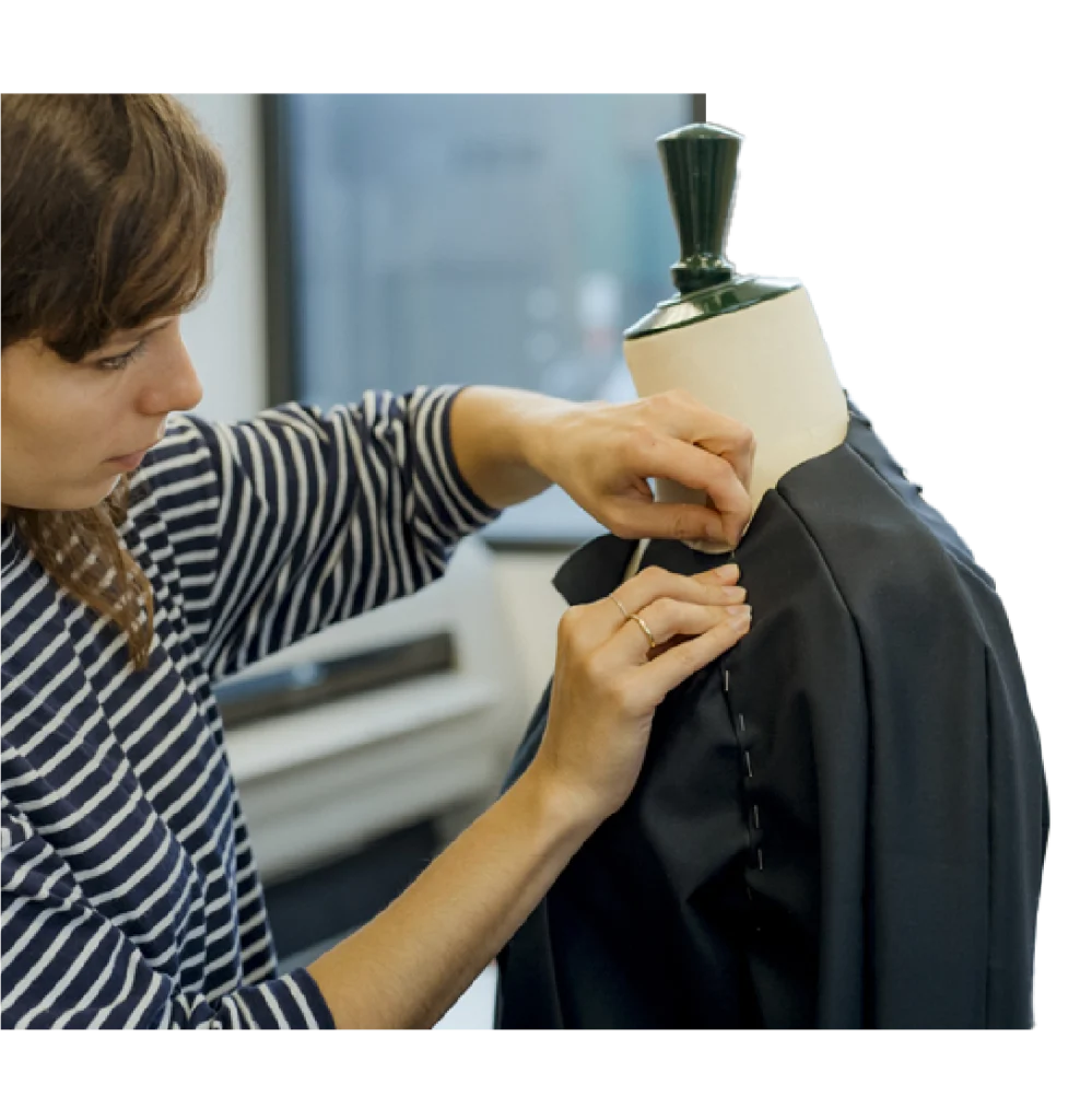 Styliste ajustant une veste sur un mannequin de couture